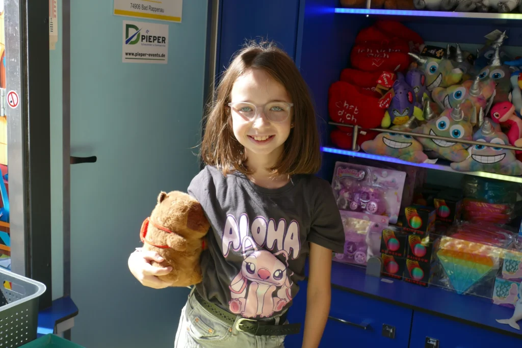 Emma mit einem Plüschtier im Spielstand ihrer Familie auf der Wertheimer Michaelismesse.